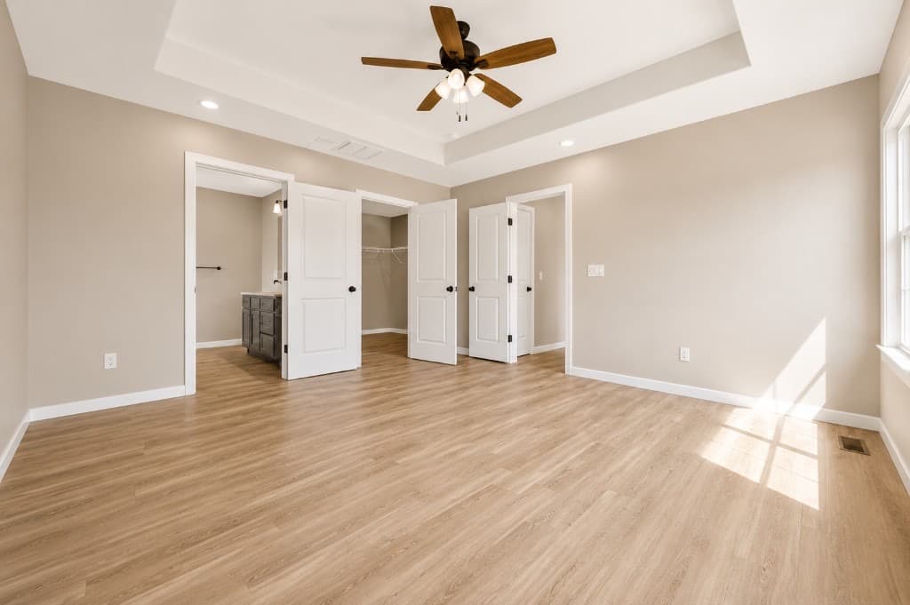 Clear Creek Properties — bedroom suite with tray ceiling and LVP flooring