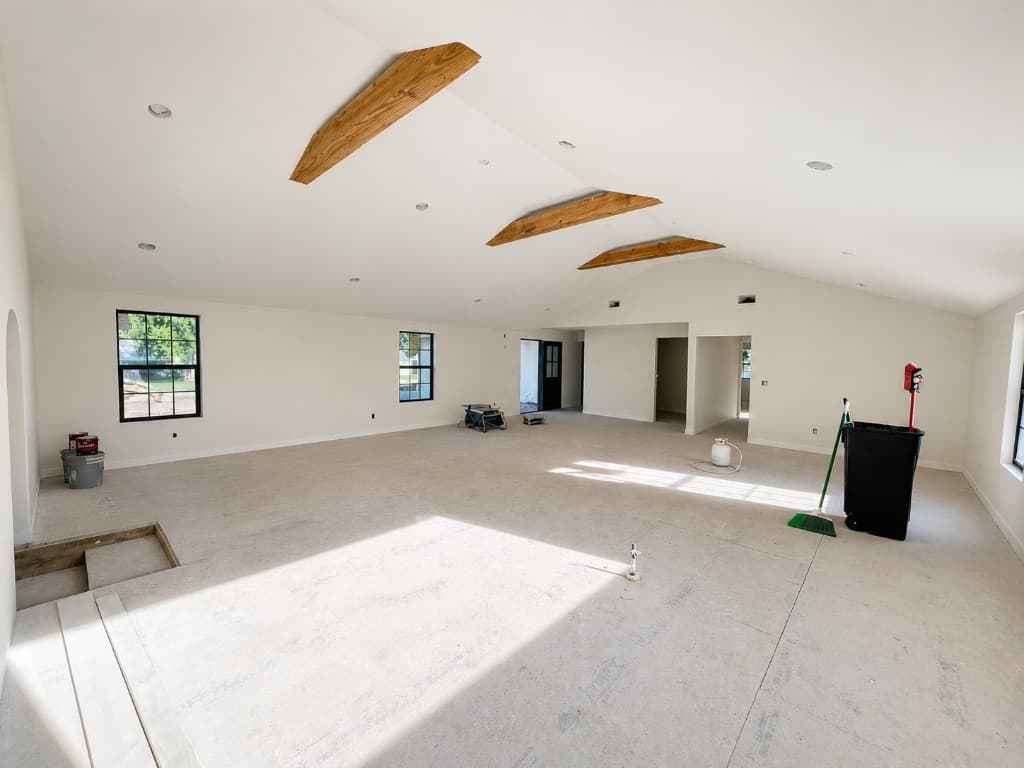 Demo and subfloor prep in open living space with exposed subfloor and jobsite cleanup